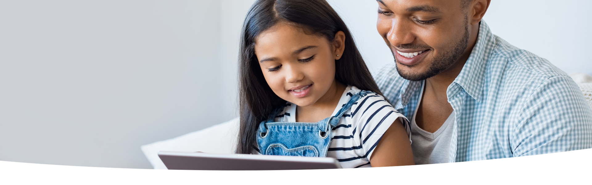 Parent and child look at a tablet together.